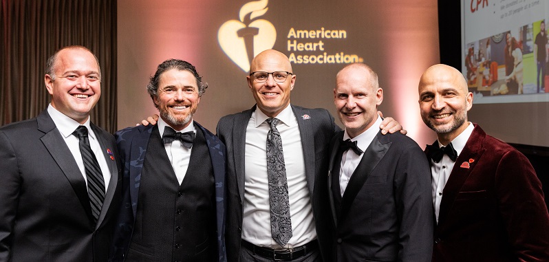 Group of five men in front of American Heart Association Heart and Torch logo